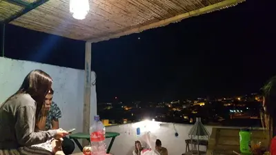 a group of people standing on a rooftop at night at Moroccan Dream Hostel in Fès