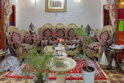 a living room with chairs and a table with plants at Dar Lalla Bouchra in Fès