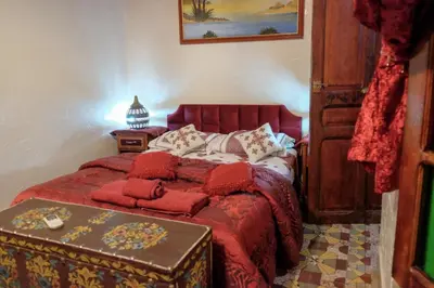 a bedroom with a bed with a red comforter at Dar Lalla Bouchra in Fès