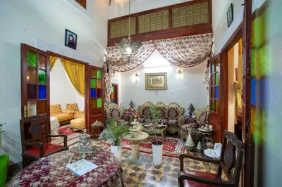 a living room with couches and a table and chairs at Dar Lalla Bouchra in Fès
