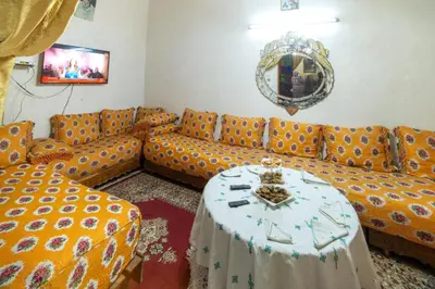 a living room with an orange couch and a table at Dar Lalla Bouchra in Fès