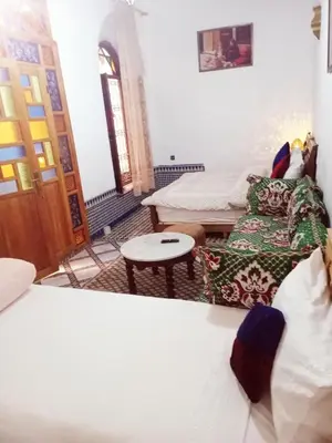 a living room with a bed and a couch at Dar Alami Salaj in Fès