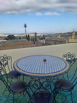 a table and chairs on a balcony with a view at Dar Alami Salaj in Fès