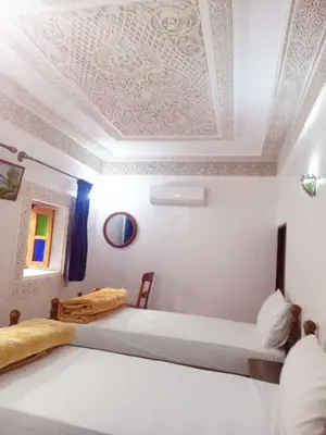 a bedroom with two beds and a coffered ceiling at Dar Alami Salaj in Fès