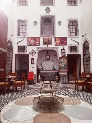 a room with a table and a couch and chairs at Dar Alami Salaj in Fès
