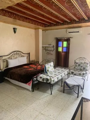 a bedroom with a bed and a bench and a window at Bab Al Madina in Fès