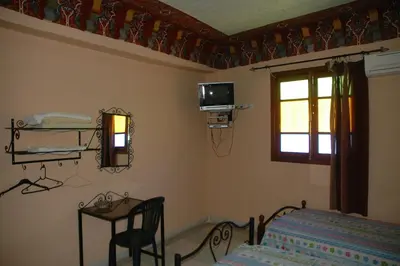 a bedroom with a bed and a table and a window at Bab Al Madina in Fès