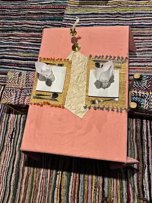 a table with a pink table cloth with a bow tie at Sahara Bedouins Camp in Hassilabied