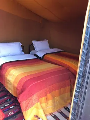 two beds sitting next to each other in a room at Sahara Bedouins Camp in Hassilabied