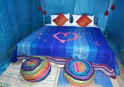 a blue bed with a heart drawn on it at Camel Trekking Desert Camp in Merzouga