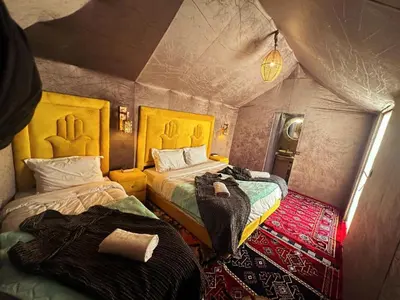 a bedroom with two beds in a room with a ceiling at Blue Sky Luxury Camp in Merzouga