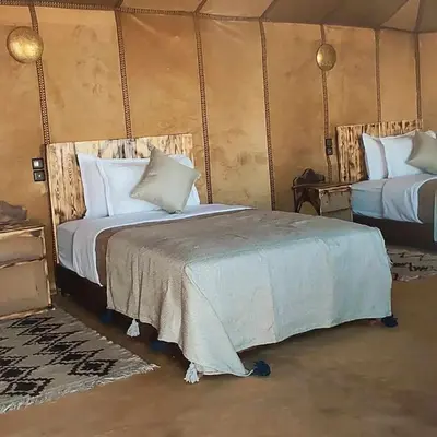 a bedroom with two beds in a tent at Blue Sky Luxury Camp in Merzouga
