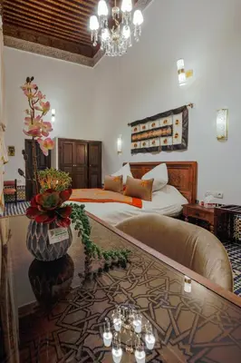 a hotel room with a bed and a glass table at Le Grand Alcazar - Riad in Fès