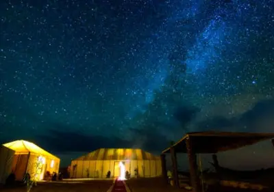 a starry night with two domes and the milky way at glamping Dunes CAMP in Merzouga