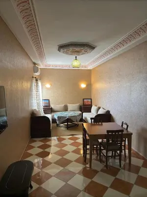 a living room with a couch and a table and chairs at Résidence dikre in Ouarzazate