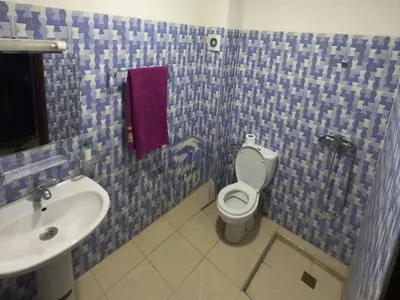 a blue tiled bathroom with a toilet and a sink at Résidence dikre in Ouarzazate