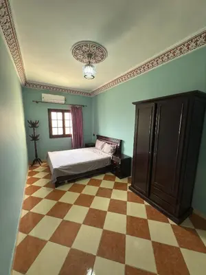 a bedroom with a bed and a checkered floor at Résidence dikre in Ouarzazate