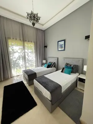 a bedroom with two beds and a chandelier at fleur de marrakech in Marrakech