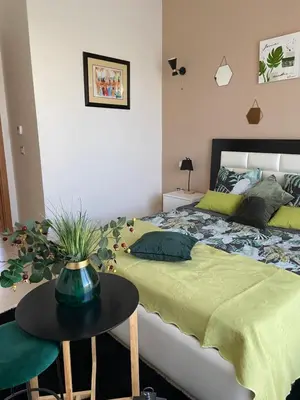 a bedroom with a bed and a table with a green blanket at fleur de marrakech in Marrakech