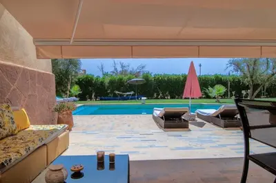 a patio with a couch and a pool at fleur de marrakech in Marrakech