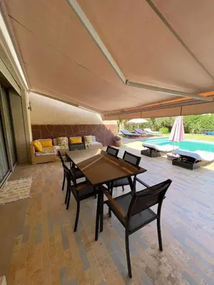 a dining room with a table and chairs and a pool at fleur de marrakech in Marrakech