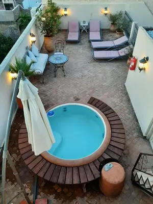 a hot tub on a patio with chairs and tables at Dar Abdesalam in Fès