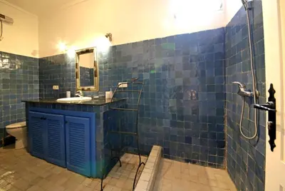 a blue tiled bathroom with a sink and a shower at Dar Abdesalam in Fès