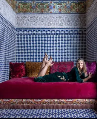 a woman laying on a bed with her legs in the air at Riad Fes Nass Zmane in Fès