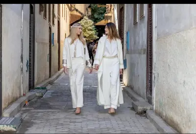 two women walking down a street holding hands at Riad Fes Nass Zmane in Fès