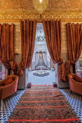 a room with curtains and a couch and a rug at Riad Fes Nass Zmane in Fès