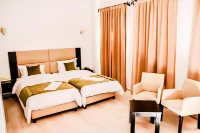 a bedroom with a bed and a chair at Motel Safari Budget in Ouarzazate