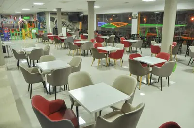 a cafeteria with tables and chairs and a playground at Motel Safari Budget in Ouarzazate