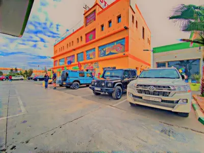 a group of vehicles parked in front of a building at Motel Safari Budget in Ouarzazate