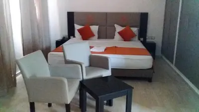a bedroom with a bed and two chairs and a table at Motel Safari Budget in Ouarzazate