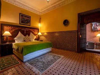 a bedroom with a green bed in a room at Riad Clé De Sol & SPA in Aghmat