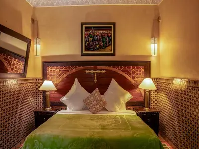 a bedroom with a large bed with two lamps at Riad Clé De Sol & SPA in Aghmat