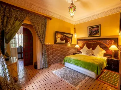 a bedroom with a green bed in a room at Riad Clé De Sol & SPA in Aghmat