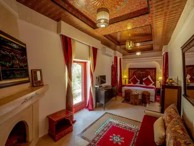 a living room with a bed and a fireplace at Riad Clé De Sol & SPA in Aghmat