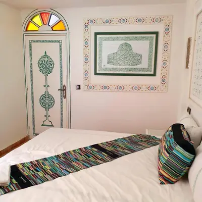 a bedroom with a bed and a window and a door at Riad golf stinia in Meknès
