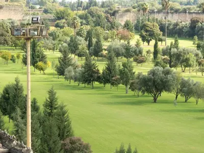 a view of a park with trees and a pole at Riad golf stinia in Meknès