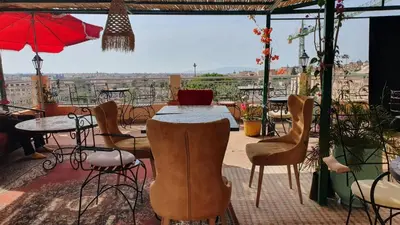 a restaurant with a table and chairs and a view at Riad golf stinia in Meknès