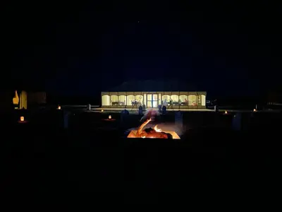 a fountain in front of a building at night at Erg Chebbi in Merzouga