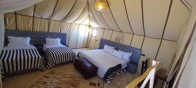 a room with two beds in a tent at Erg Chebbi in Merzouga