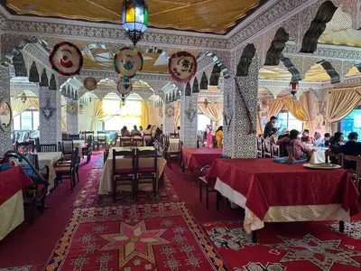 a restaurant with tables and people sitting at them at AUBERGE ROYAL PALMAS in Tinerhir