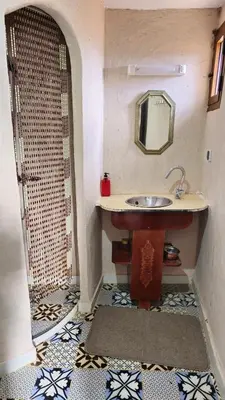 a bathroom with a sink and a shower with a mirror at Tizi Maison d'Hôtes in Telouet