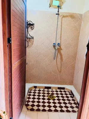 a shower with a checkered floor in a bathroom at Camping auberge palmeraie d'amezrou in Zagora