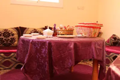 a table with a purple table cloth on it at Chez zakaria guest in Erfoud