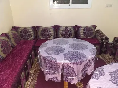 a purple couch with a table in a living room at Chez zakaria guest in Erfoud