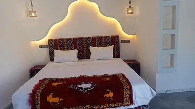 a bedroom with a bed with a blanket on it at Auberge oued dades in Boumalne
