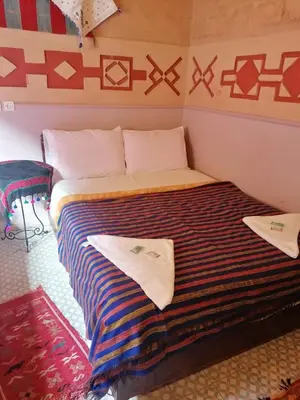 a bed in a room with two towels on it at Riad Atlas Berbère in Boumalne
